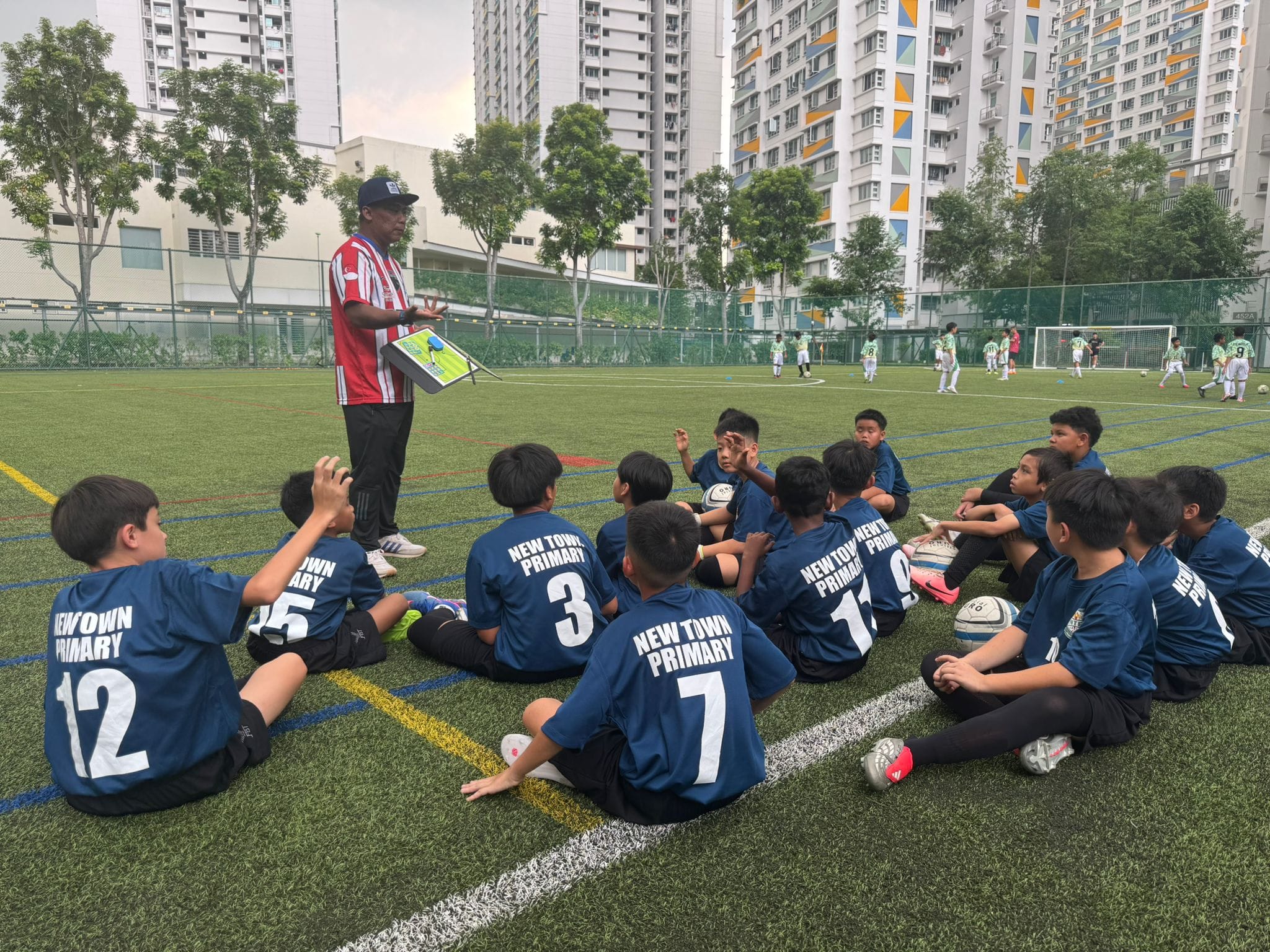 The football instructor is giving instructions and the finer tactical ways in which the football players are expected to put into their practice